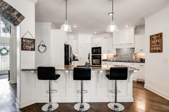 kitchen with dark stone counters, pendant lighting, white cabinets, and black appliances