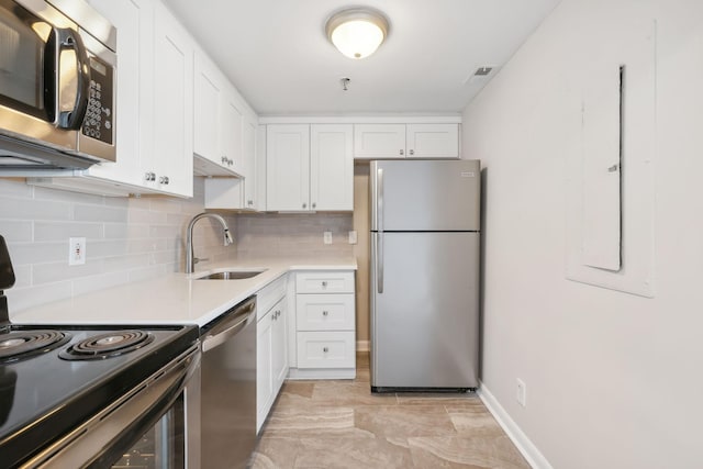 kitchen featuring decorative backsplash, sink, white cabinetry, and stainless steel appliances