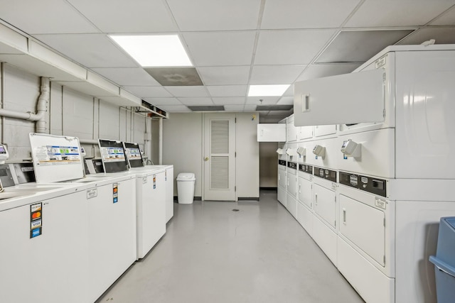 900 19th Ave S Unit 103, Nashville, TN 37212 - kitchen with stacked washer and clothes dryer, washing machine and clothes dryer, a drop ceiling, white cabinetry, and light countertops