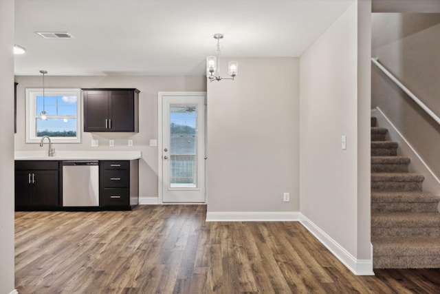 kitchen featuring a chandelier, wood-type flooring, stainless steel dishwasher, and pendant lighting