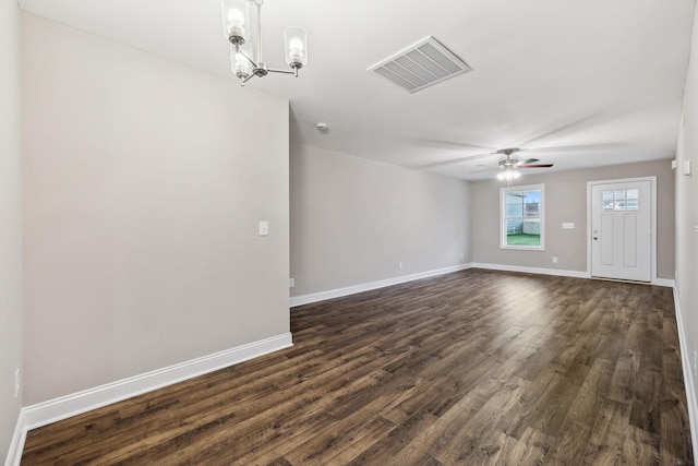 unfurnished living room with ceiling fan with notable chandelier and dark wood-type flooring