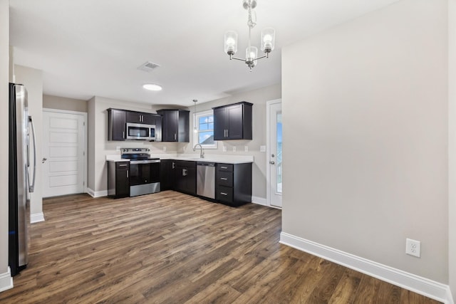 kitchen with a chandelier, decorative light fixtures, dark hardwood / wood-style flooring, and stainless steel appliances