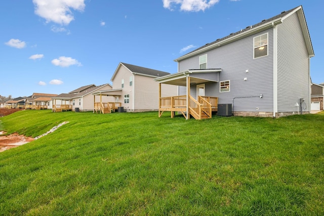 rear view of property featuring a deck, central AC unit, and a lawn