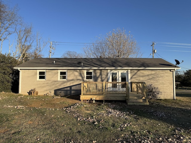 rear view of house with a deck and a lawn