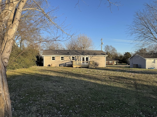 back of house with a lawn and a wooden deck