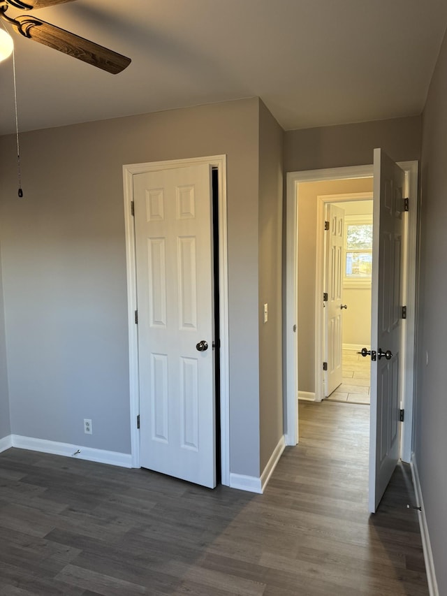 unfurnished bedroom featuring ceiling fan and dark hardwood / wood-style floors