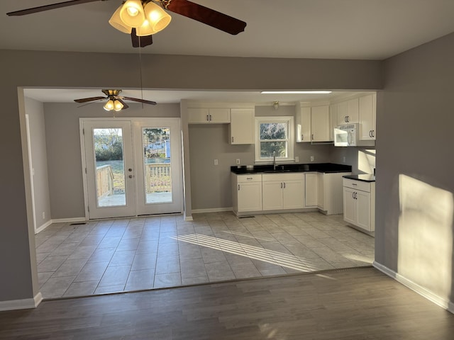 kitchen featuring white cabinetry, french doors, light hardwood / wood-style floors, and sink