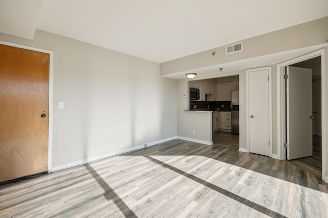 unfurnished living room with wood-type flooring