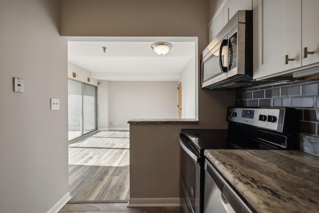 kitchen with decorative backsplash, stainless steel appliances, and light hardwood / wood-style floors