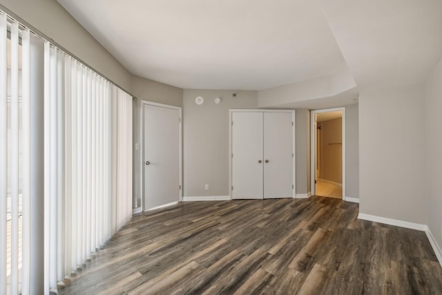 unfurnished bedroom with dark wood-type flooring and ensuite bath