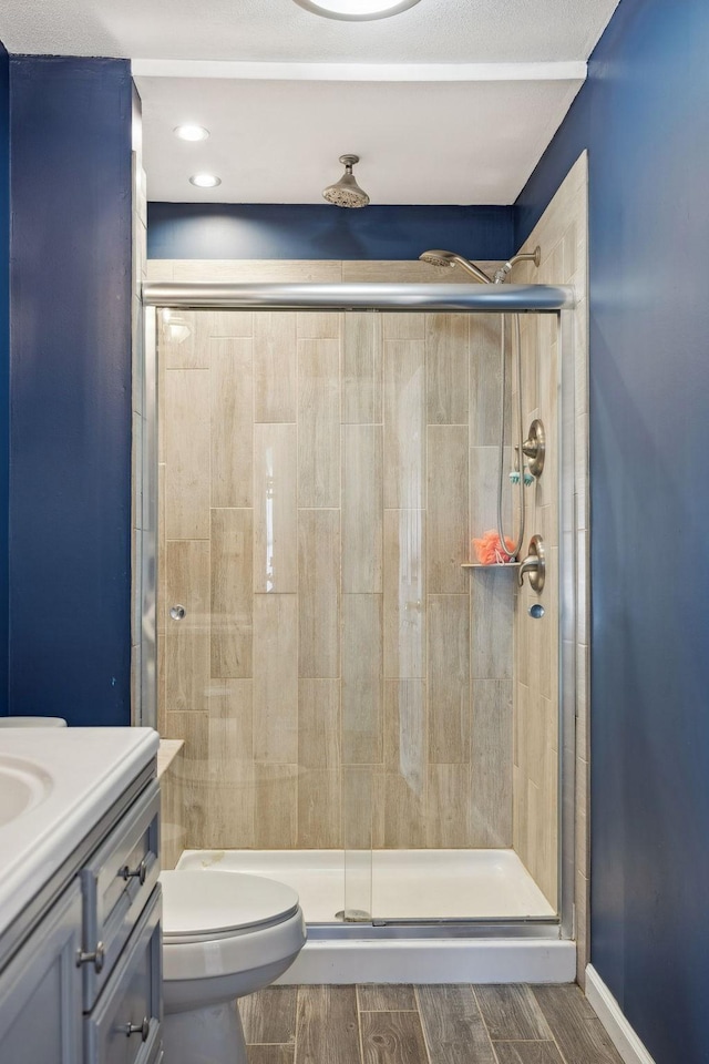 bathroom featuring vanity, toilet, and walk in shower