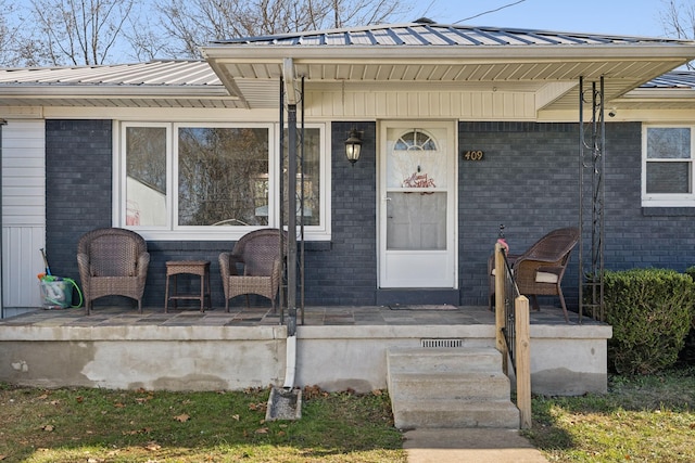 view of exterior entry featuring covered porch