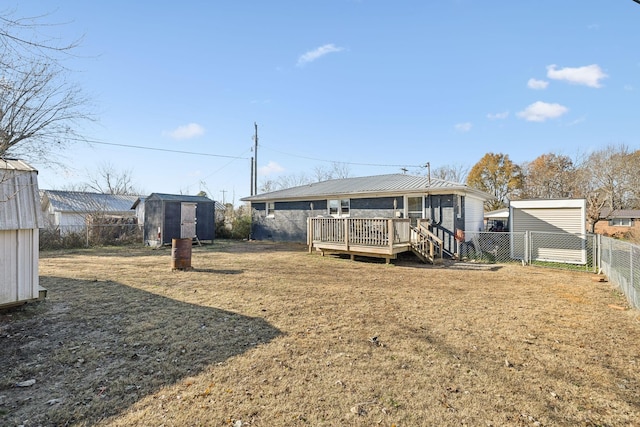 back of house with a wooden deck, a yard, and a shed