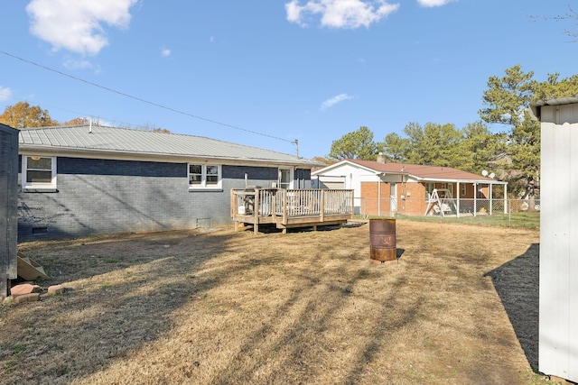 rear view of property featuring a lawn and a wooden deck