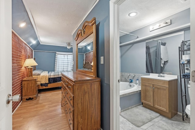 bathroom with hardwood / wood-style floors, a bathtub, vanity, lofted ceiling, and a textured ceiling