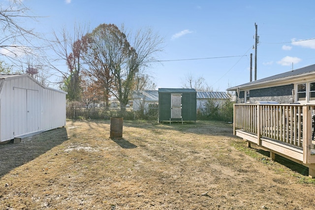 view of yard featuring a wooden deck and a storage unit