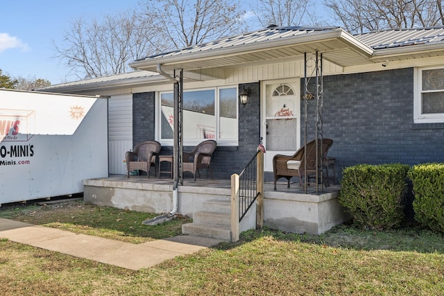 entrance to property featuring a porch and a yard