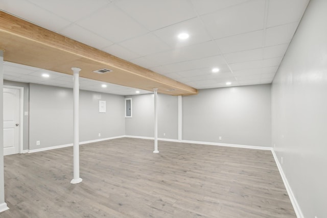 basement featuring a paneled ceiling and wood-type flooring