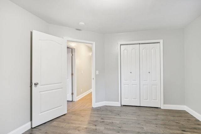 unfurnished bedroom featuring light wood-type flooring and a closet