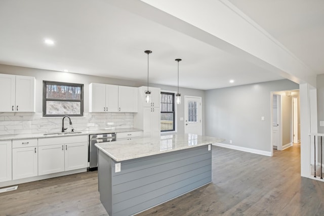 kitchen with a kitchen island, white cabinetry, and a wealth of natural light