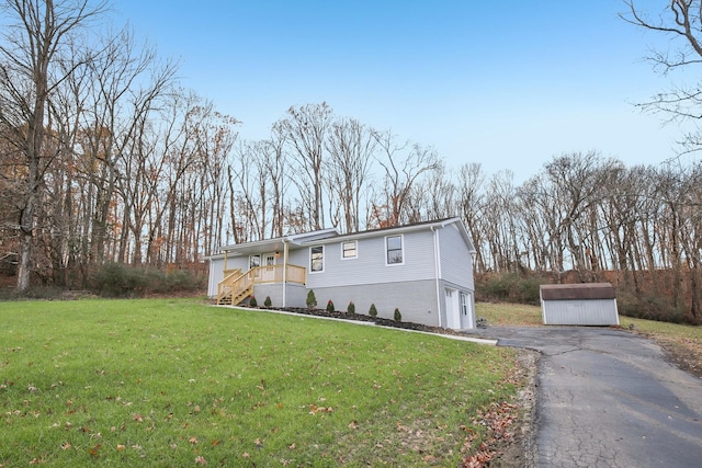 view of front of house with a front yard, a garage, and a storage unit