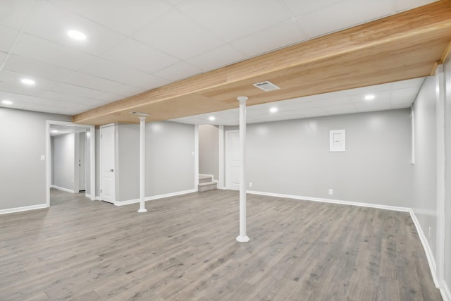 basement with hardwood / wood-style flooring and a drop ceiling