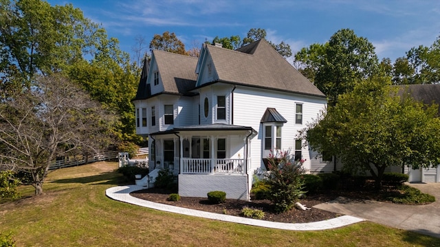 view of side of property with a lawn and a porch