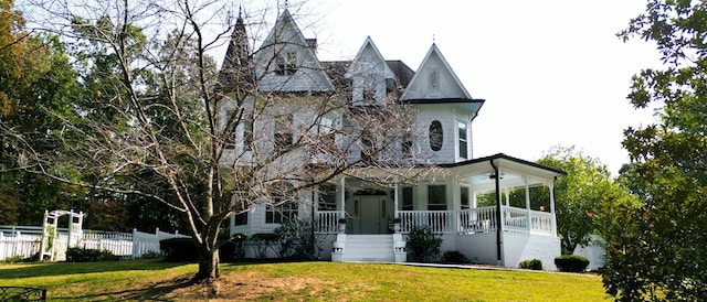 view of front facade featuring covered porch and a front yard