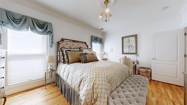 bedroom with light hardwood / wood-style floors and crown molding