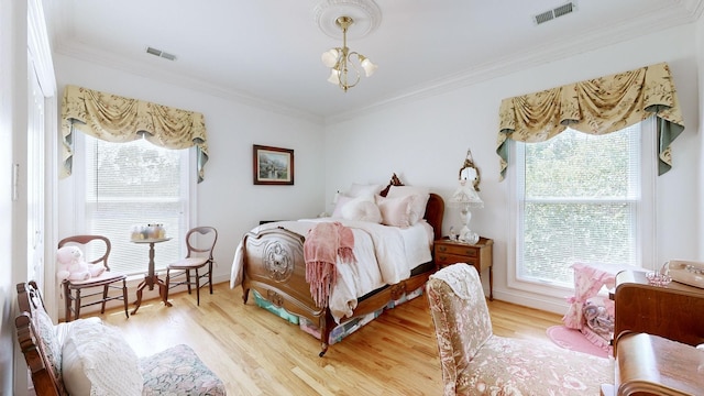 bedroom featuring hardwood / wood-style flooring, an inviting chandelier, multiple windows, and ornamental molding