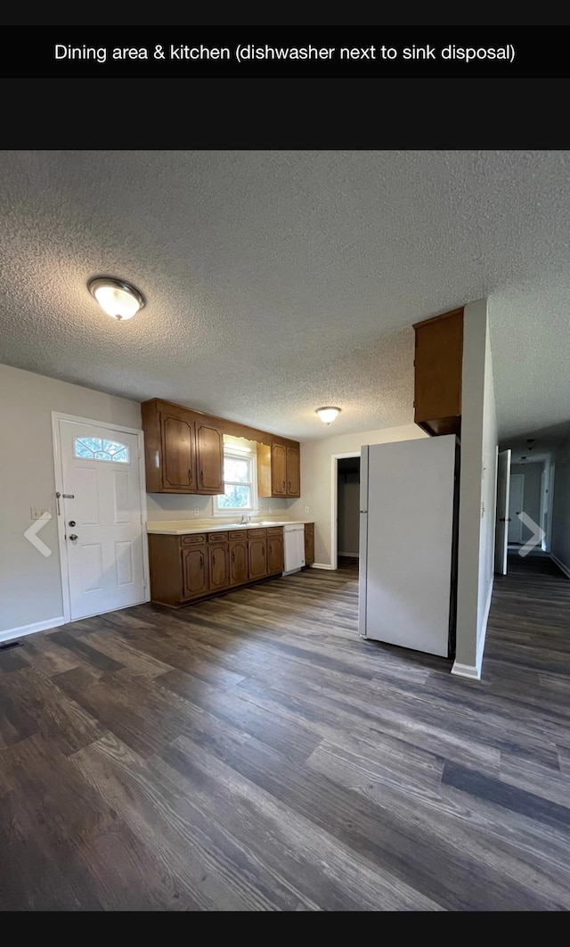 kitchen featuring dark hardwood / wood-style flooring, white refrigerator, and a textured ceiling