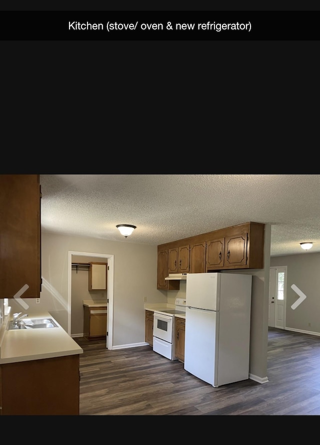 kitchen with dark hardwood / wood-style flooring, white appliances, and a textured ceiling