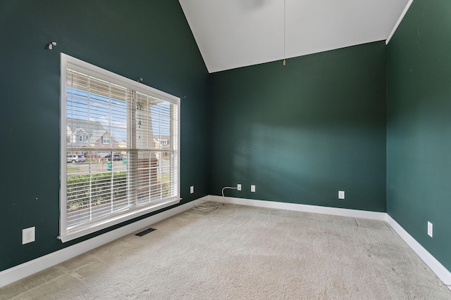 carpeted spare room featuring lofted ceiling