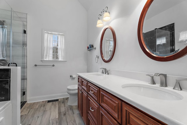 bathroom with a shower with shower door, toilet, wood-type flooring, and vanity