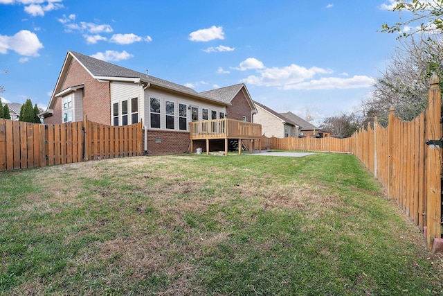 rear view of property featuring a deck, a yard, and a patio