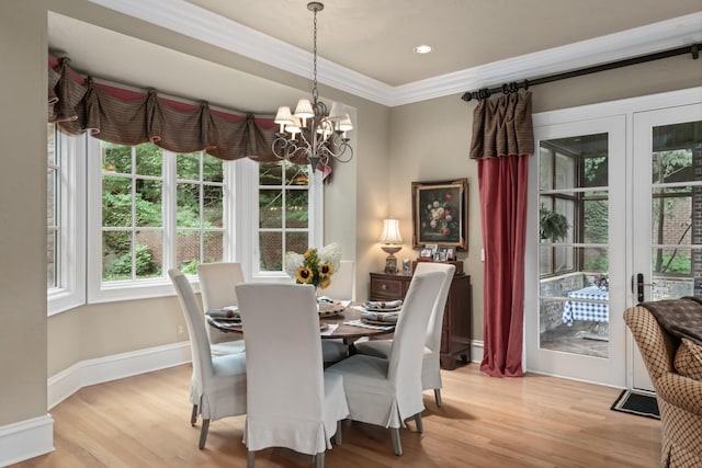 dining room with crown molding, light hardwood / wood-style flooring, and a notable chandelier