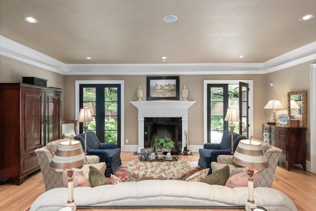 living room featuring crown molding, plenty of natural light, french doors, and light hardwood / wood-style flooring