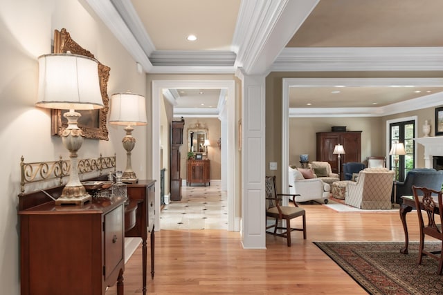 hallway with light wood-type flooring and ornamental molding