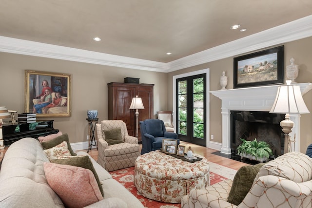 living room featuring crown molding, a fireplace, and light wood-type flooring