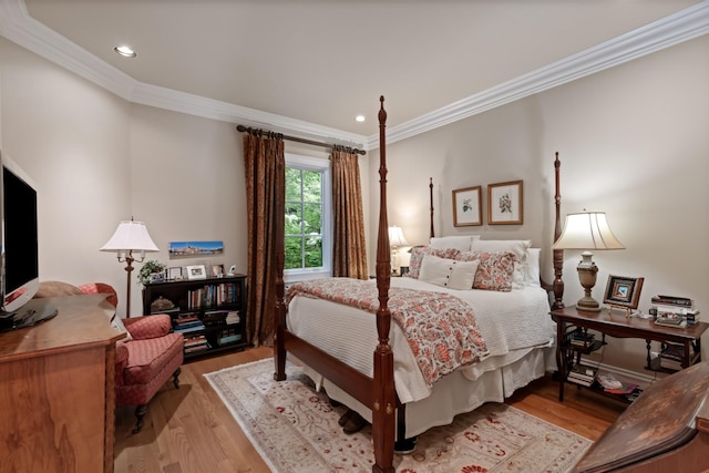 bedroom with ornamental molding and light hardwood / wood-style flooring