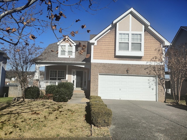 view of front of property featuring a front yard, a garage, and a porch