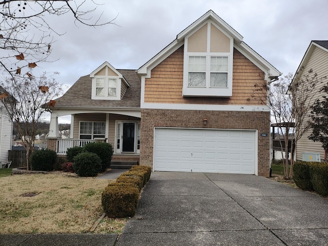 view of front of house with a porch, a front lawn, and a garage