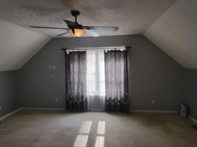 bonus room with vaulted ceiling, ceiling fan, and light carpet