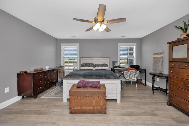 bedroom featuring light hardwood / wood-style floors, multiple windows, and ceiling fan