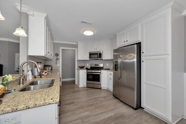 kitchen featuring sink, hanging light fixtures, light hardwood / wood-style floors, white cabinetry, and stainless steel appliances