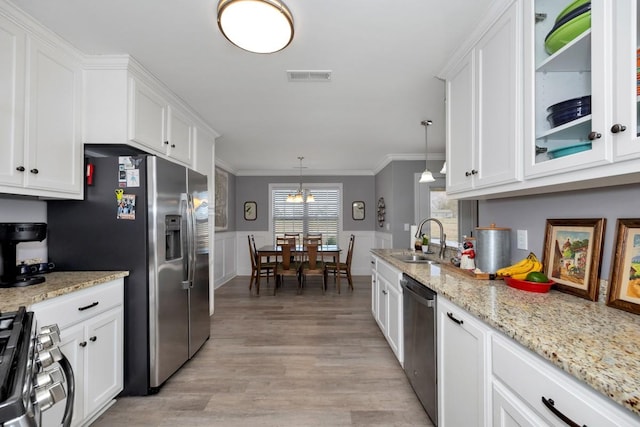 kitchen with pendant lighting, white cabinetry, sink, and stainless steel appliances