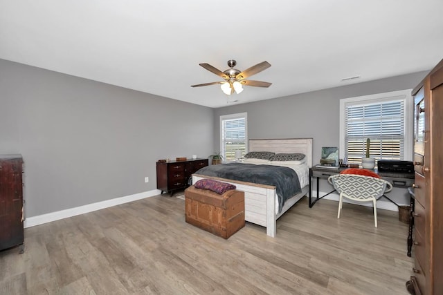 bedroom with hardwood / wood-style floors, ceiling fan, and multiple windows