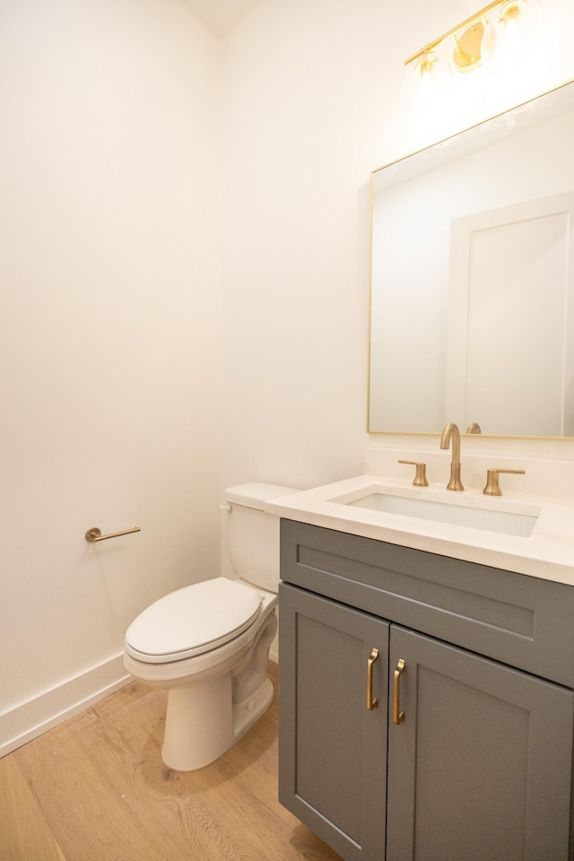 bathroom featuring hardwood / wood-style floors, vanity, and toilet