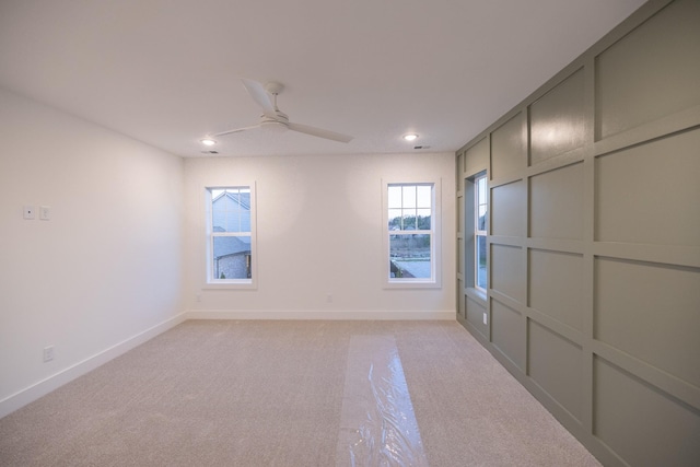 carpeted spare room featuring ceiling fan