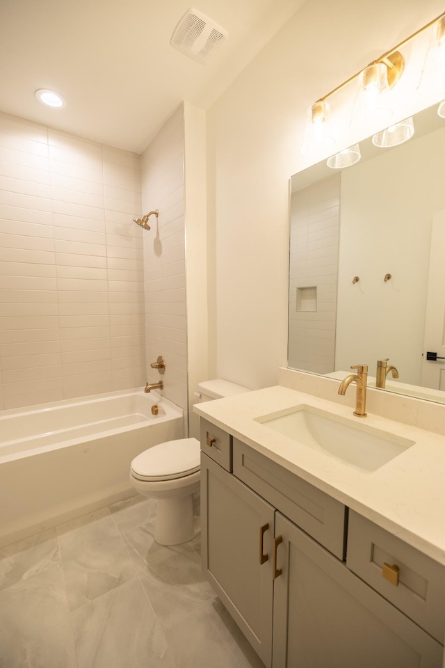 full bathroom with toilet, vanity, and tiled shower / bath